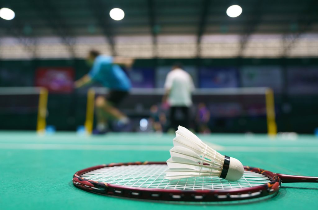 shuttlecock on green badminton playing court